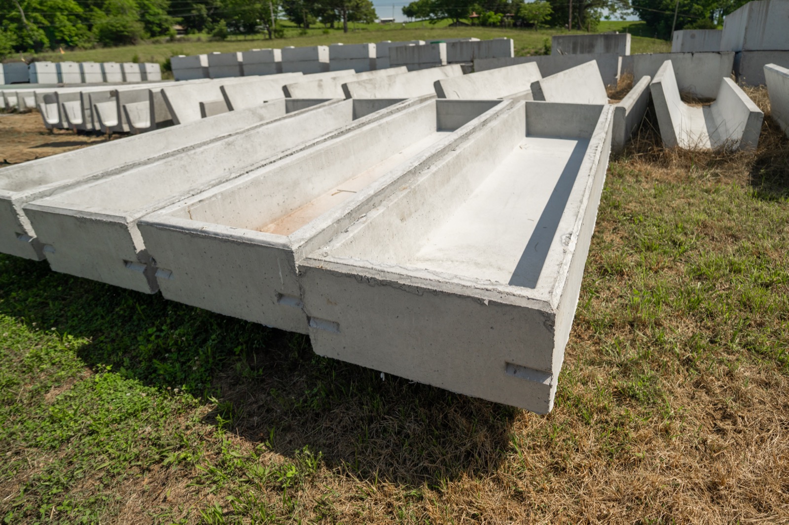 Concrete bunk feeders stacked in the Daniels Septic and Precast yard, Tazewell, TN