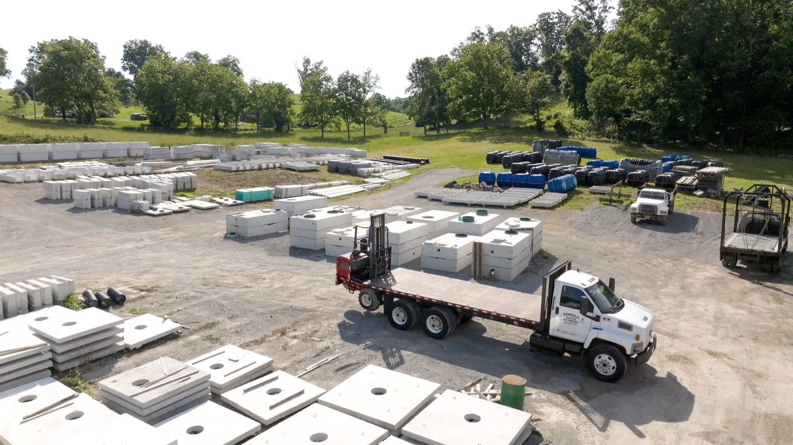 Aerial view of the Daniels Septic and Precast yard in Tazewell, TN with concrete tanks, plastic tanks, and delivery trucks