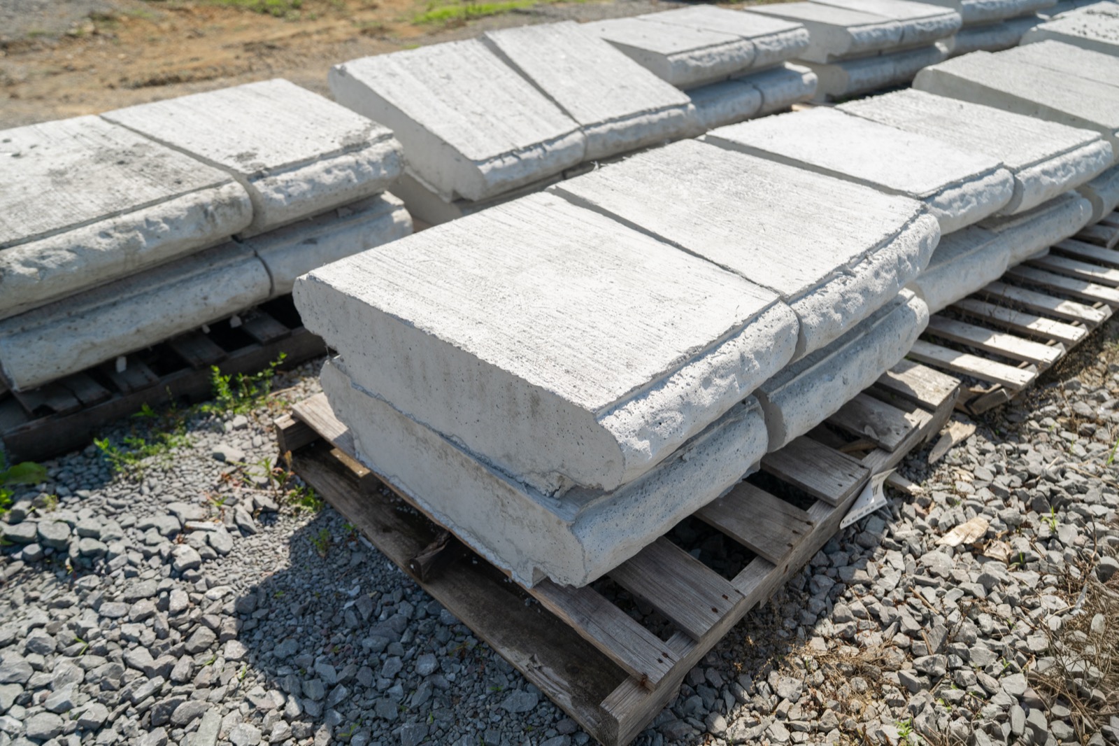 Stacked precast concrete retaining wall blocks on pallets at the Daniels Septic and Precast yard, Tazewell, TN